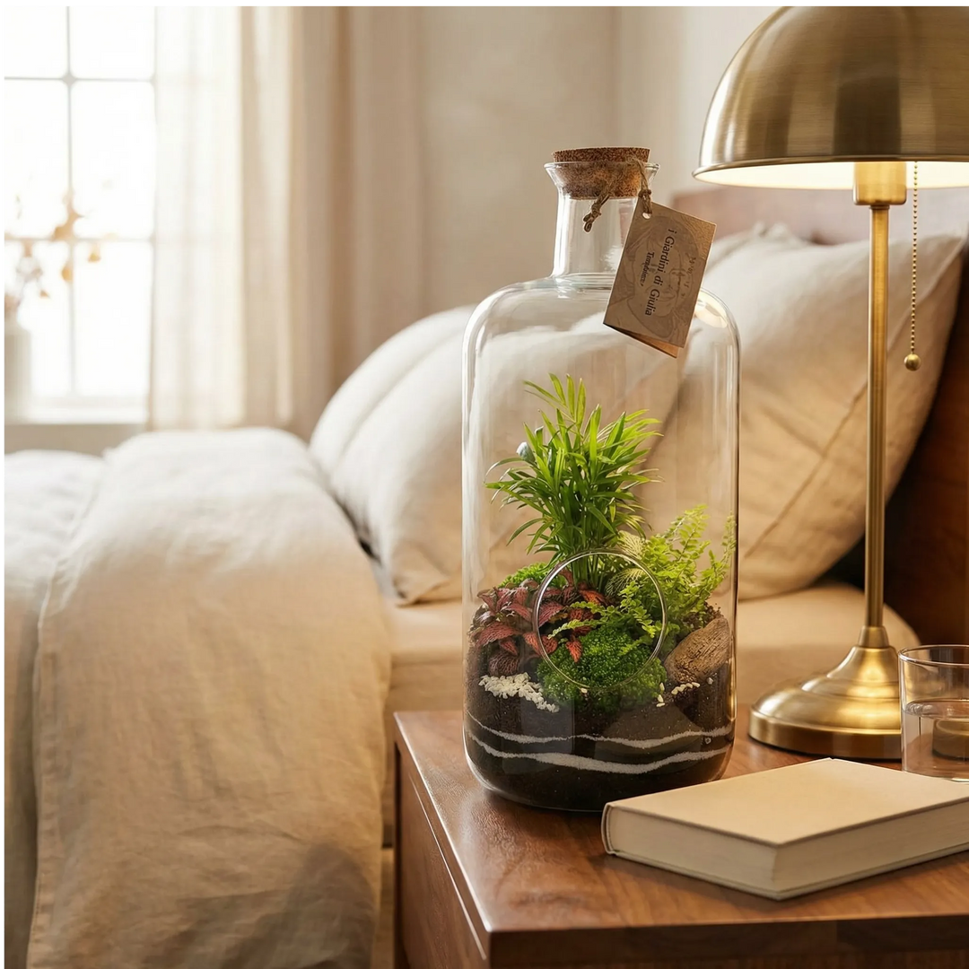 Terrarium bottiglia Alba su comodino camera da letto con lampada ottone e lenzuola beige