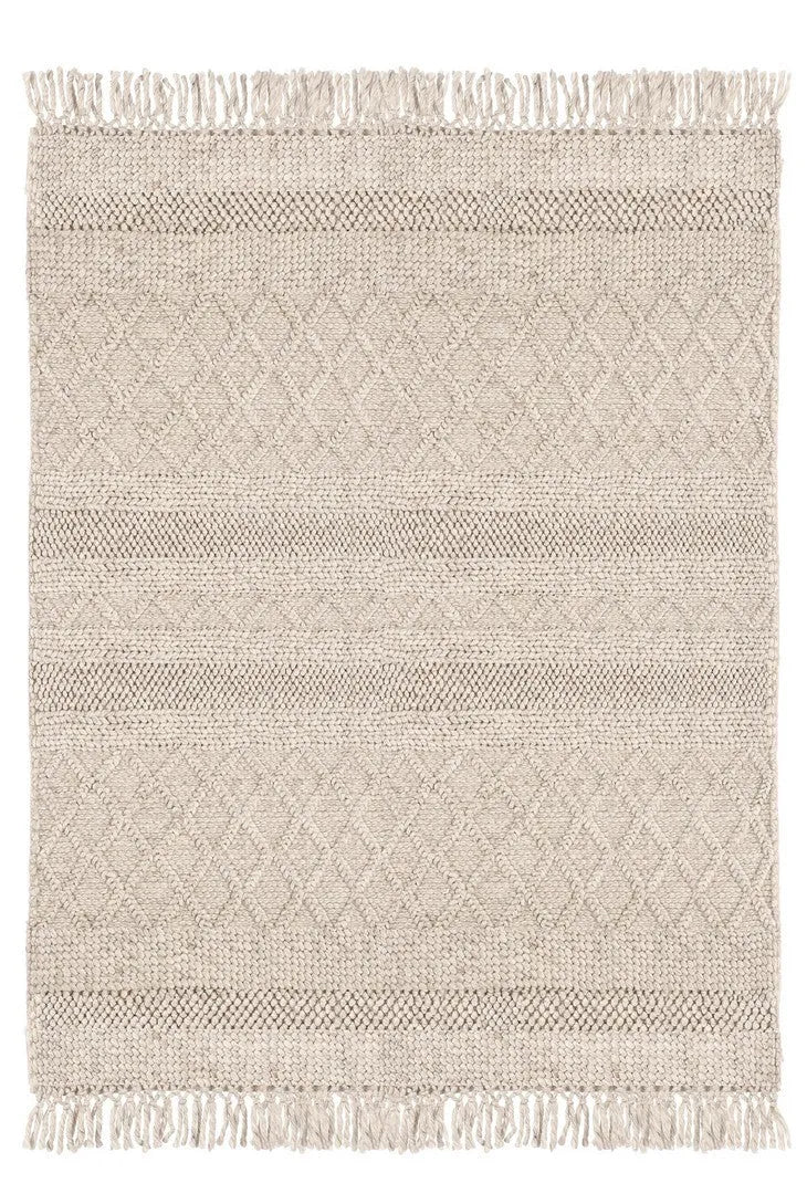 Vista dall’alto di un tappeto intrecciato beige con motivi a rombi e frange, ideale per arredamenti naturali e minimalisti