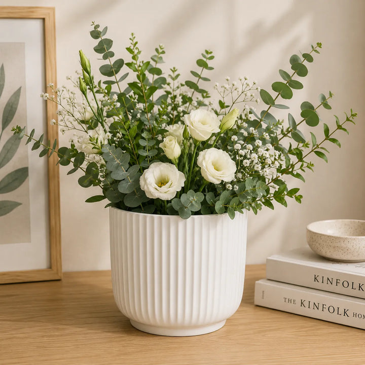 Vaso Pitti bianco rigato in ceramica con composizione floreale di lisianthus bianchi, eucalipto e verde decorativo, ideale per arredare soggiorni, ingressi e ambienti dallo stile moderno e raffinato.