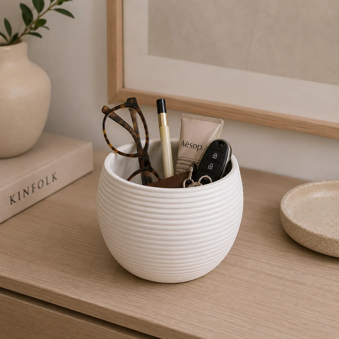 Vaso Sally bianco in ceramica utilizzato come contenitore per chiavi, occhiali e accessori personali su mobile d’ingresso dallo stile minimal e contemporaneo.