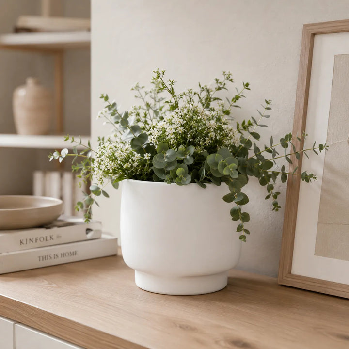 Vaso Sweet bianco in ceramica con composizione di eucalipto e piccoli fiori bianchi, ideale per arredare soggiorni e ambienti moderni con uno stile naturale.