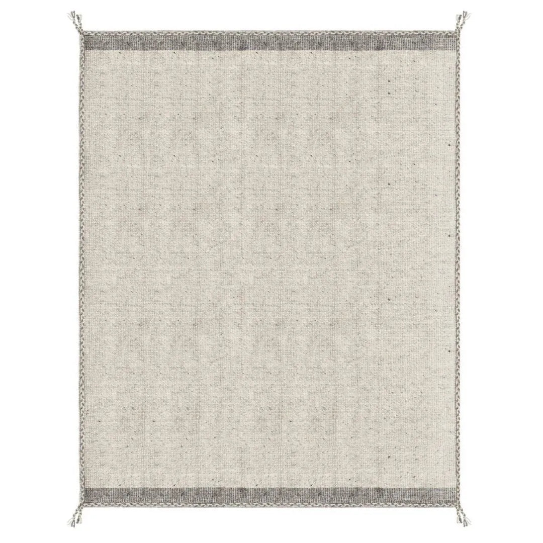 Tappeto Chathu beige in soggiorno moderno con libreria in legno

